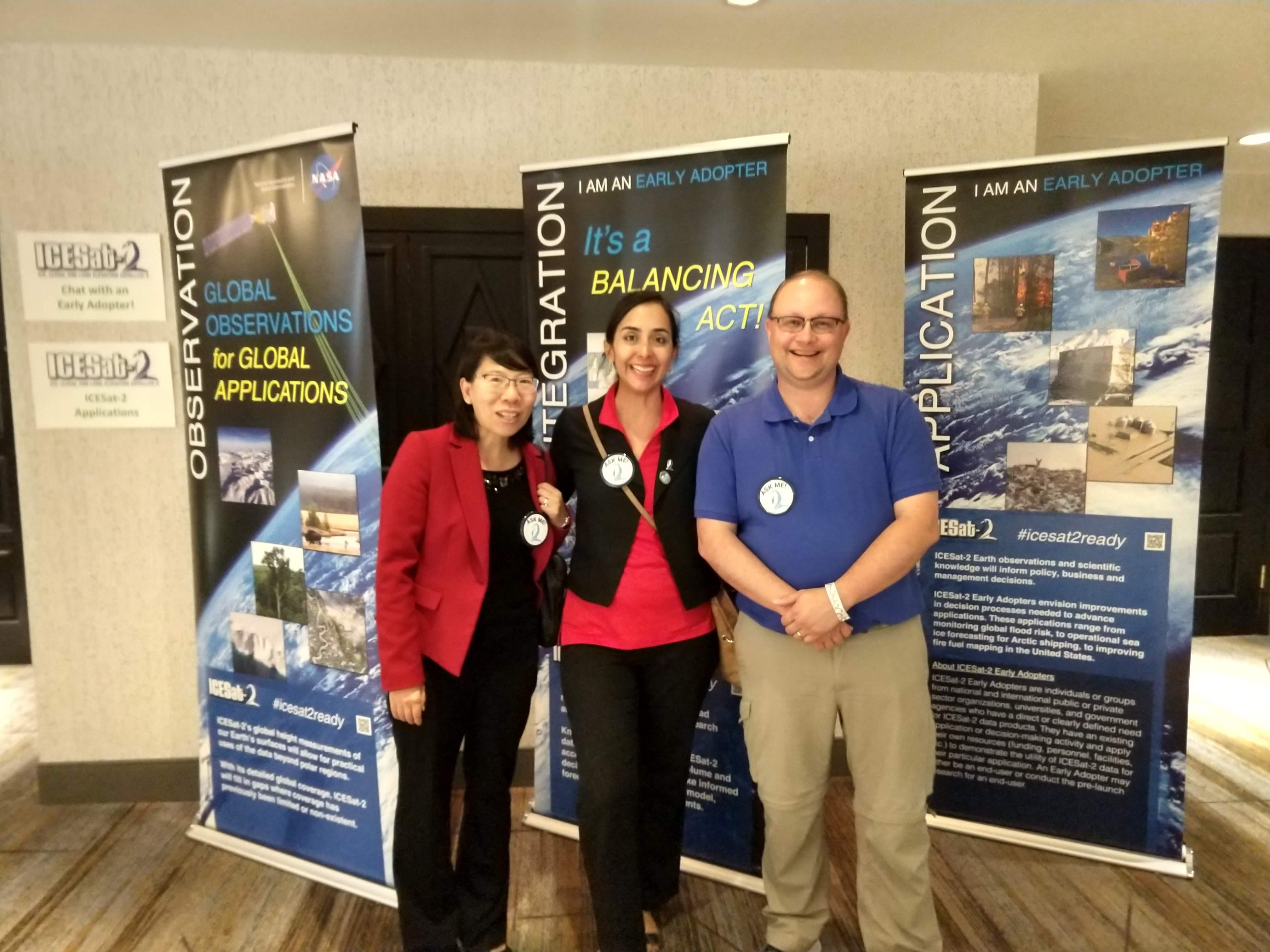 three people standing in front of NASA banners